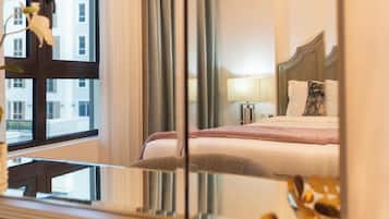 Une chambre d’hôtel avec un lit, des tables de chevet, une lampe et une fenêtre avec des rideaux.