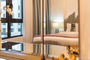 A hotel room with a bed, bedside tables, a lamp, and a window with curtains. - bnbme - La Cote 3 - 1BR (Dubai)