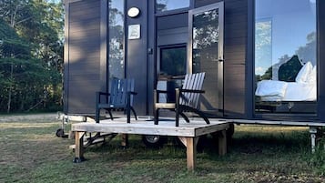 Una cabina moderna e compatta con una terrazza, un'area salotto e un letto a vista all'interno.