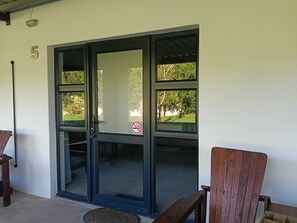 A building entrance with a glass door, a number '5' on the wall, and a no-smoking sign. - Cape Mesa Starting Point (Cape Town)