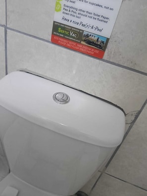A toilet with a Septic Tank sticker on the wall above it. - Cape Mesa Starting Point (Cape Town)