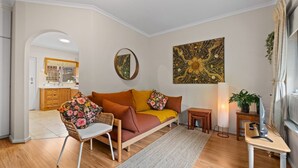 Ein modernes Wohnzimmer mit einer Couch, einem Sessel, einem kleinen Tisch und einer Stehlampe.