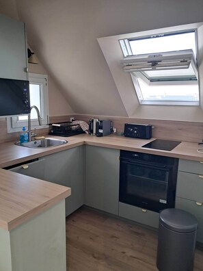A modern kitchen with a skylight, built-in dishwasher, and a compact sink. - A beautiful 2-room apartment facing the ocean (Piriac-sur-Mer)