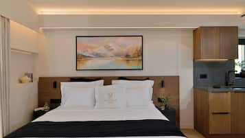 Habitación de hotel con cama, un cuadro, mesita de noche, un florero y vistas al exterior.