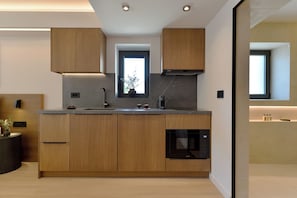 A modern kitchen with wooden cabinets, a built-in oven, and a window above the sink.
