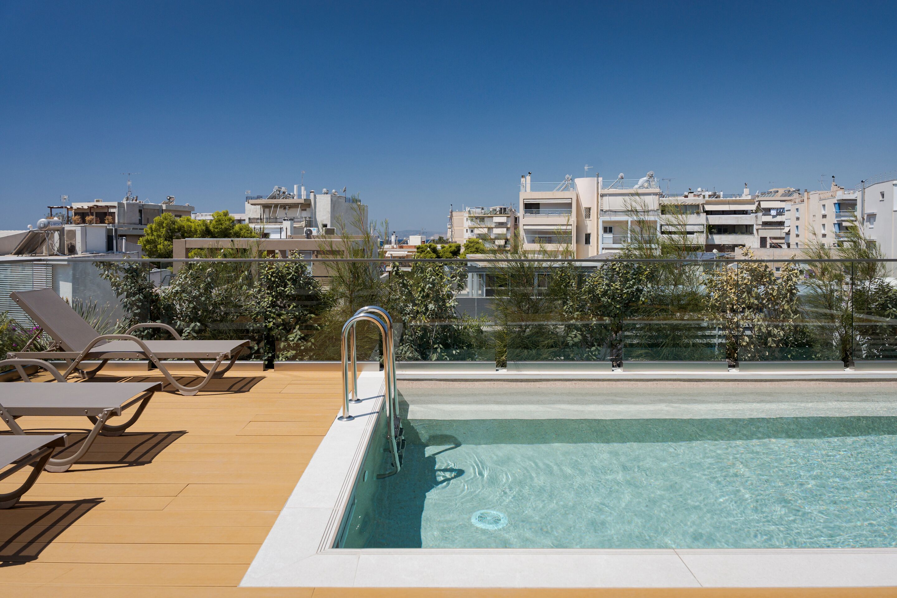 A rooftop pool with lounge chairs and a clear view of the cityscape.