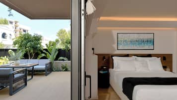 Una habitación de hotel moderna con una cama, un cuadro y vistas al exterior.