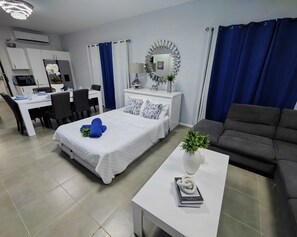 A modern bedroom with a bed, a desk, and a sofa. - Chic Blue Oasis Modern Curaçao Willemstad Retreat (Willemstad)