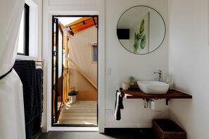 Une salle de bain avec un lavabo blanc, un miroir et un porte-serviettes.