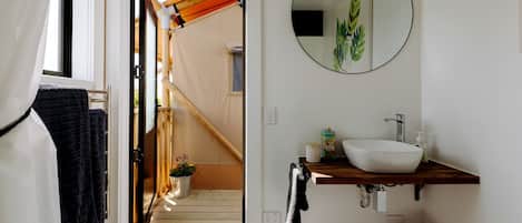 Une salle de bain avec un lavabo blanc, un miroir et un porte-serviettes.