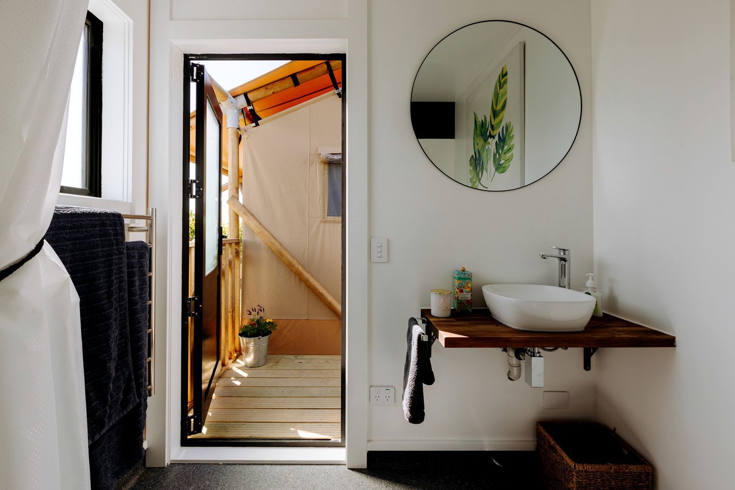 A bathroom with a white sink, a mirror, and a towel rack.