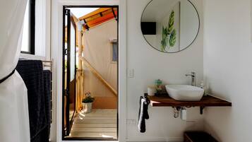 A bathroom with a white sink, a mirror, and a towel rack.