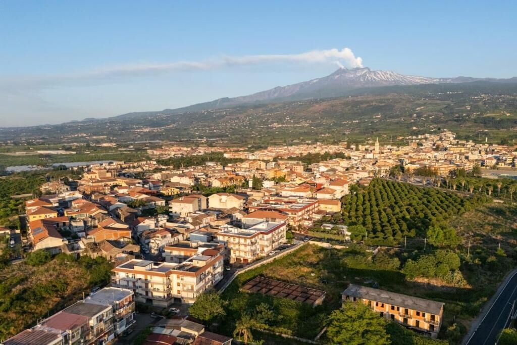 Una cittadina con una montagna sullo sfondo, caratterizzata da edifici residenziali e aree aperte.