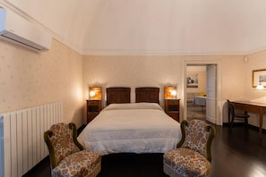 Ein Hotelzimmer mit einem Bett, zwei Stühlen, einem Schreibtisch und einem Heizkörper.