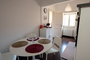 Ein Essbereich mit einem runden Tisch, Stühlen und einem weißen Schrank.