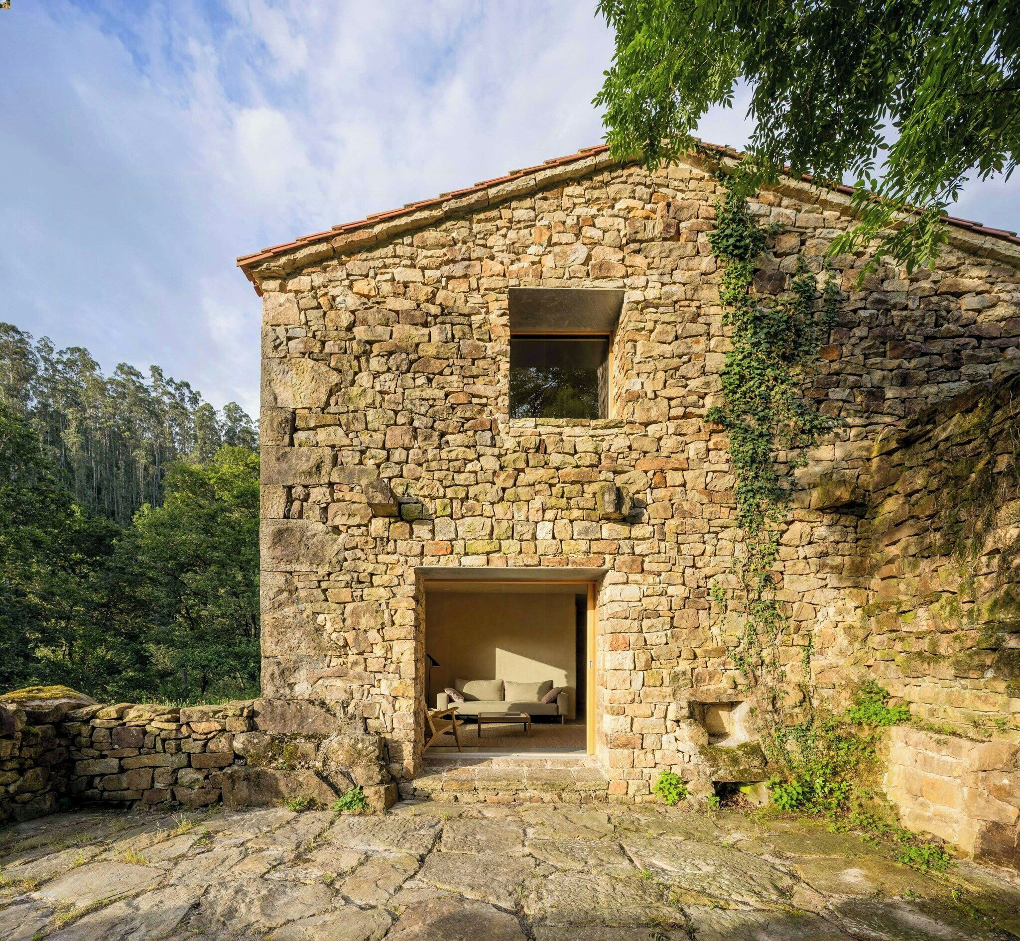 A stone house with a wooden door and a window.