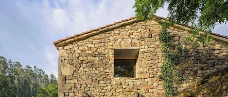 A stone house with a wooden door and a window.