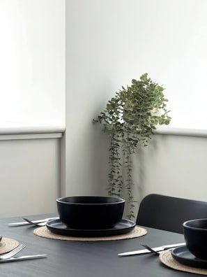 A dining table with a black bowl, a potted plant, and a chair. - Bright 2BD 2bath Sleeps 6 London View (London)