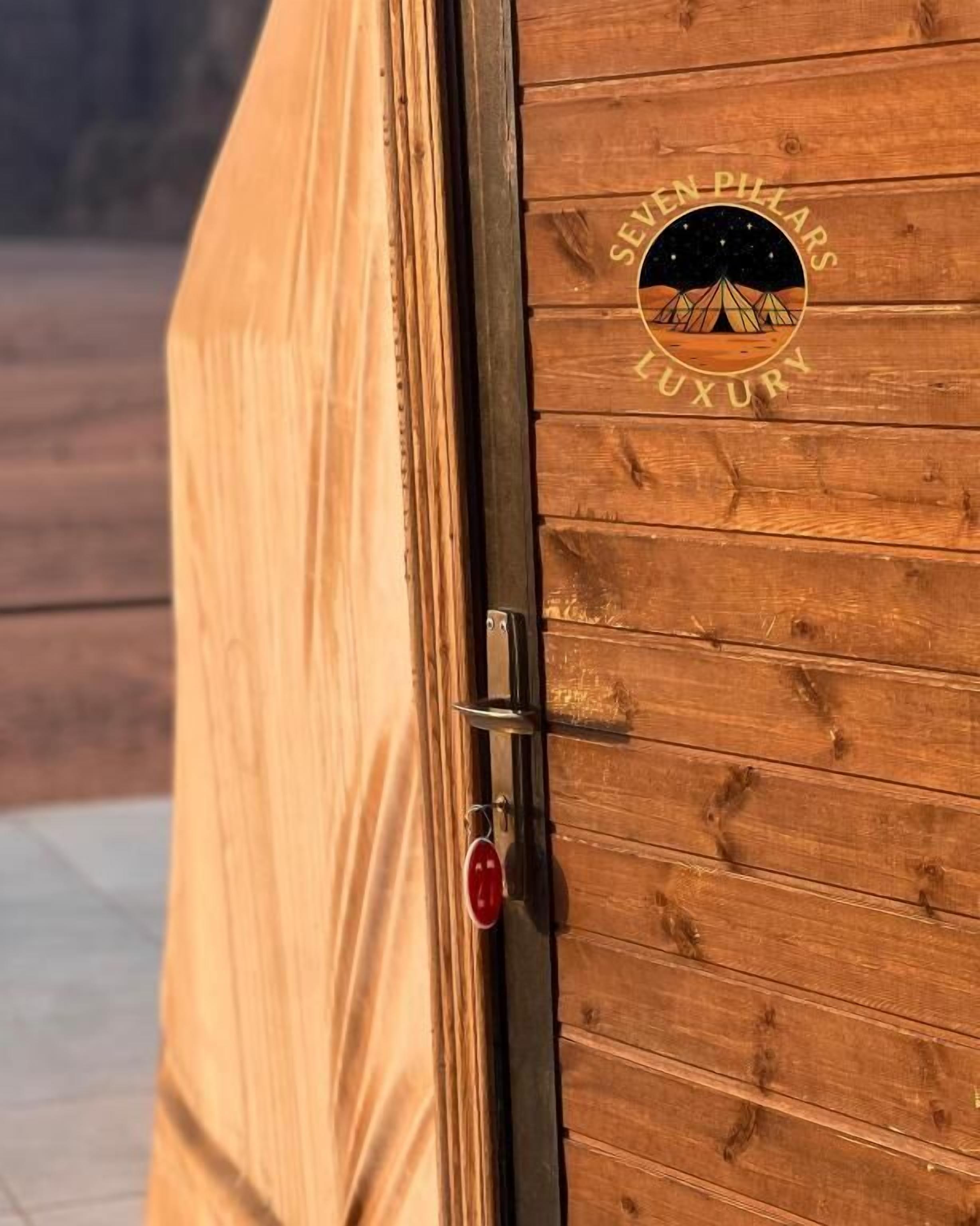 A wooden door with a logo that reads 'SEVEN PILLARS LUXURY.'