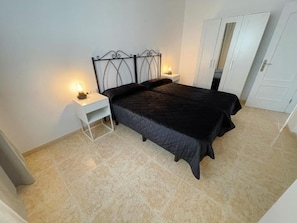 A bedroom with a bed, nightstands, and a wardrobe. - Edificio Don Diego (Los Cristianos)