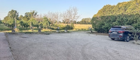 A gravel parking area with a car parked on the right.