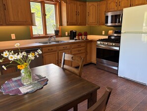 A kitchen with wooden cabinets, a stainless steel stove, and a refrigerator.