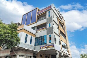 Un hotel de varios pisos con un letrero que dice 'Hotel Sapthami Luxury Rooms & Mini Function Hall'.
