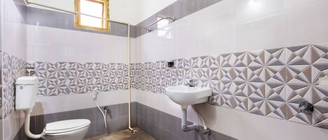A bathroom with a toilet, sink, and shower.