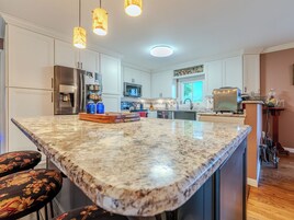 A kitchen with white cabinets, a granite countertop, and a built-in oven.