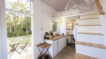 A compact kitchen with a dining area, a small table, and a view of the outdoors.