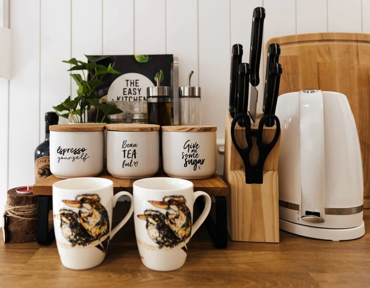Un comptoir de cuisine avec des tasses à café, une machine à café et un ensemble de couteaux.