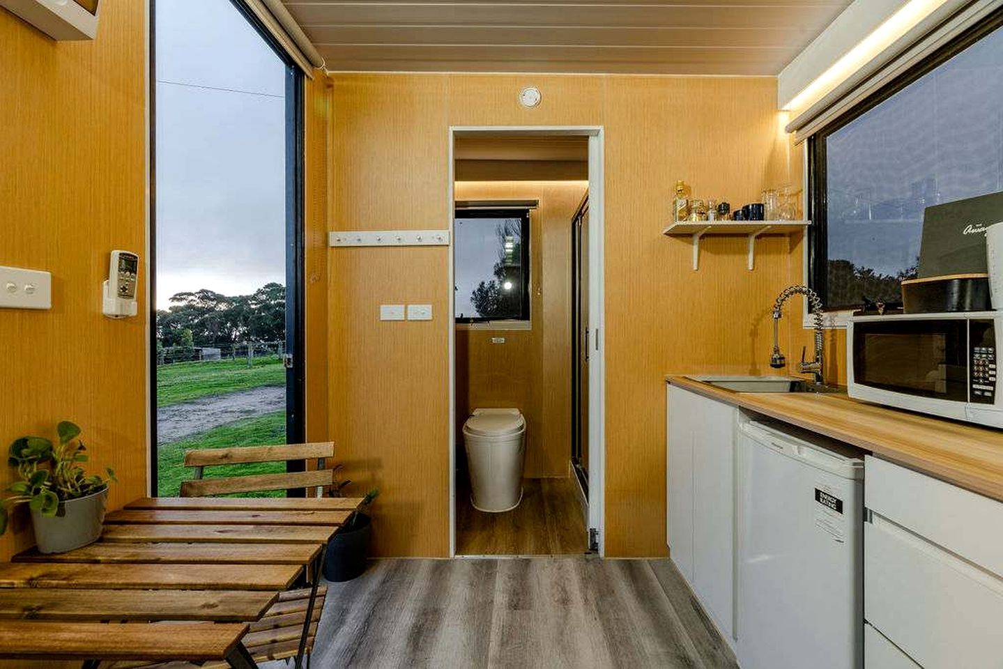 Une cuisine compacte équipée d’un four à micro-ondes, d’un évier et d’un plan de travail en bois.