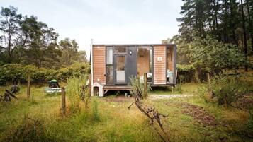 A modern, two-story cabin with a wooden exterior and a visible deck area.