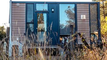A modern, single-story building with a dark blue exterior, large windows, and a visible door.