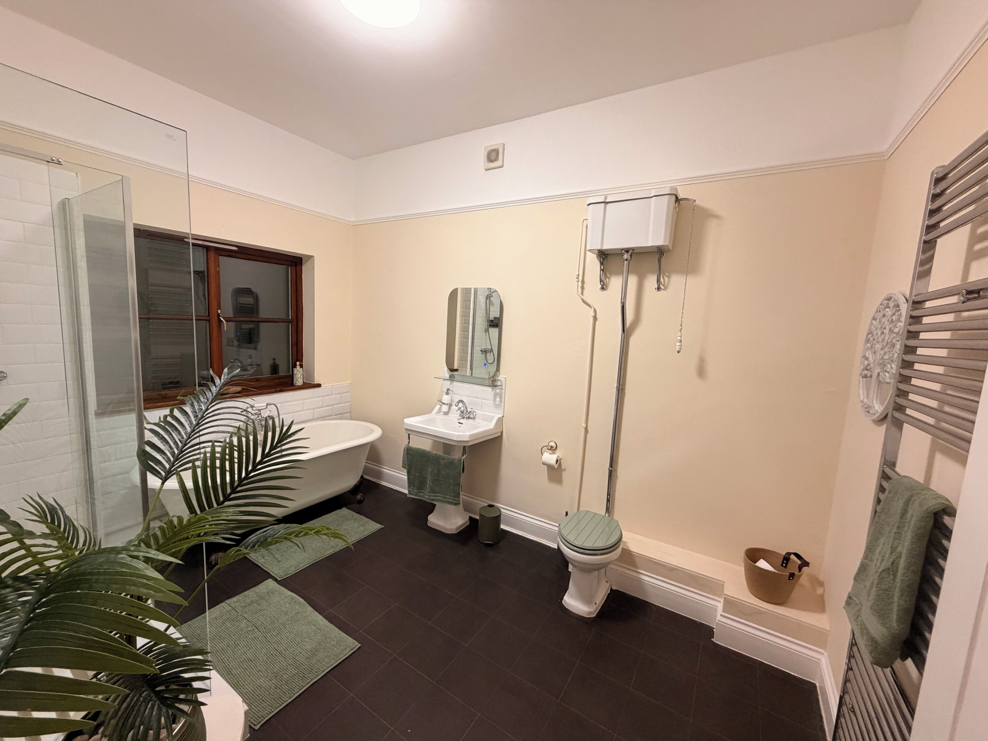 Un baño con bañera, inodoro, lavabo y cabina de ducha de vidrio.