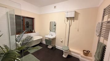 Un baño con bañera, inodoro, lavabo y cabina de ducha de vidrio.