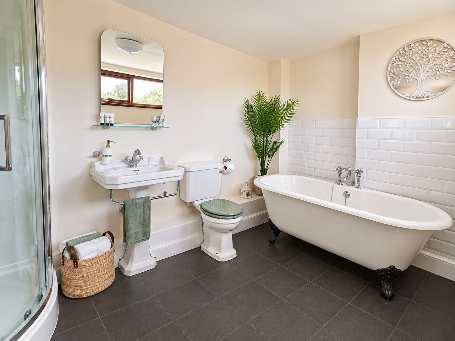 Un baño con cabina de ducha de vidrio, una bañera independiente, un inodoro con asiento verde y un lavamanos con espejo.
