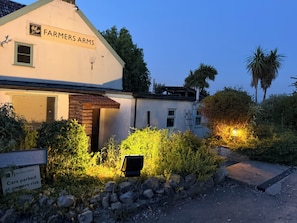 A building with a sign reading 'Farmers Arms' and another sign stating 'Cars parked at owners risk.'
