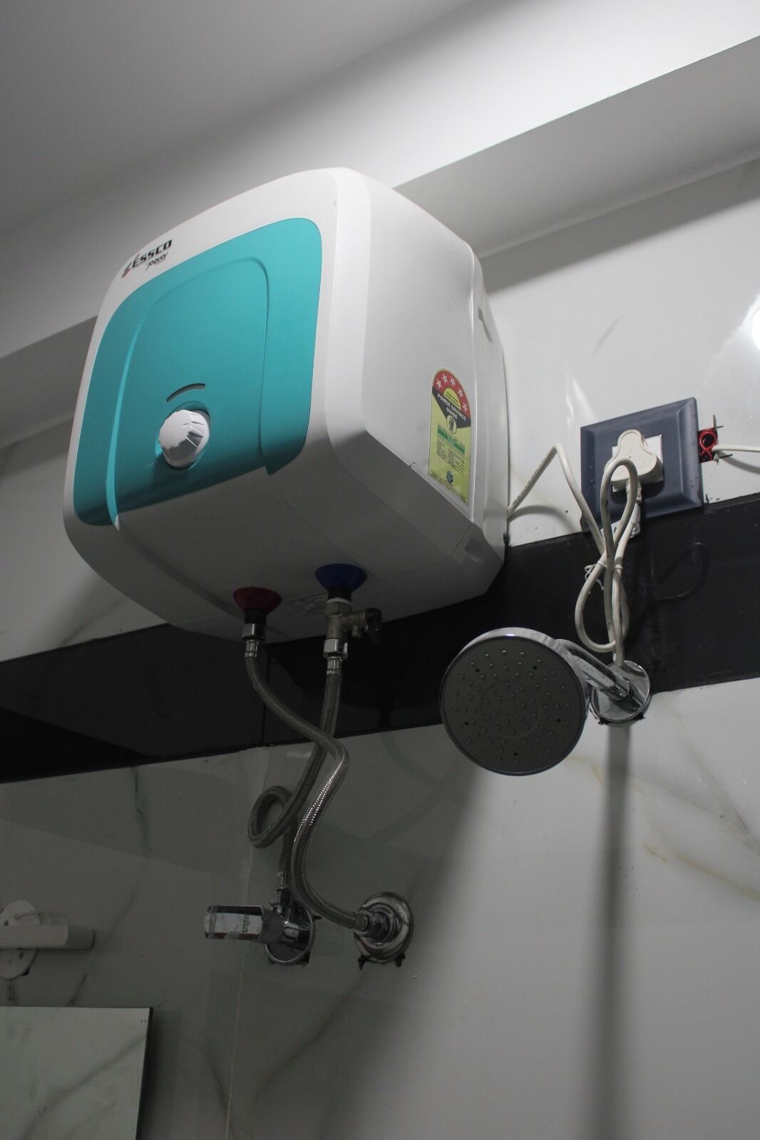 Un chauffe-eau fixé au mur, muni d’un bouton de commande et d’une étiquette de sécurité.