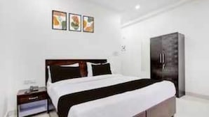 A hotel room with a bed, a wardrobe, and a nightstand. - Classic Green Residency (New Delhi)