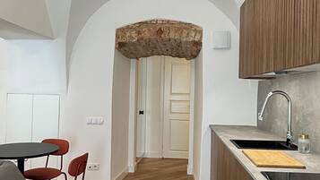 Eine moderne Küche mit einer zentralen Kochinsel, Holzschränken und einem eingebauten Ofen.