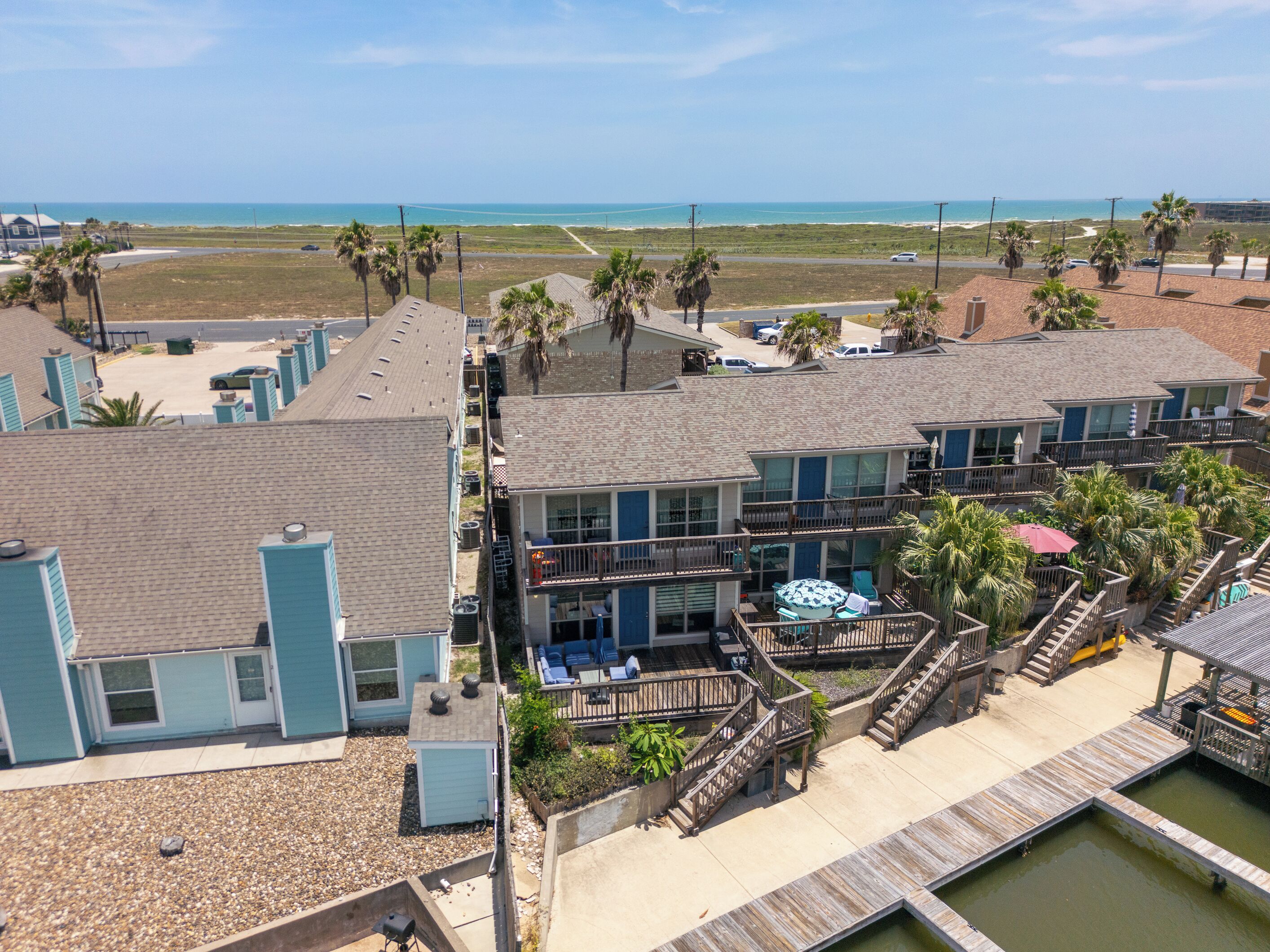 A beachfront hotel with multiple balconies, a pool area, and a view of the ocean.