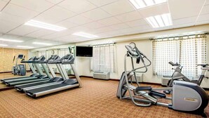 A gym with treadmills, an elliptical, and a stationary bike.