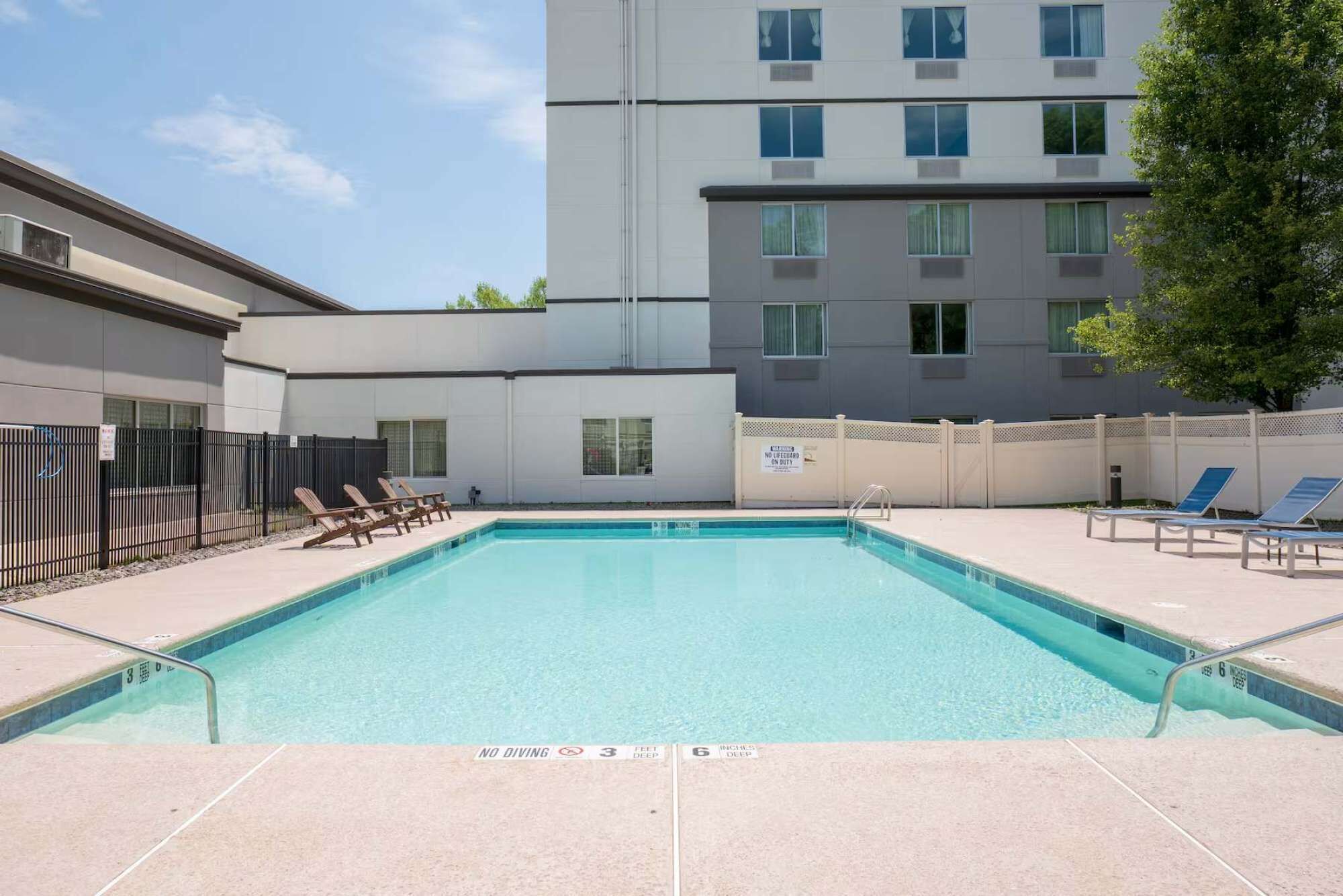 A swimming pool with lounge chairs and a no diving sign.