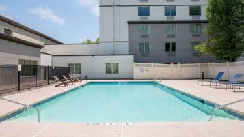 A swimming pool with lounge chairs and a no diving sign.