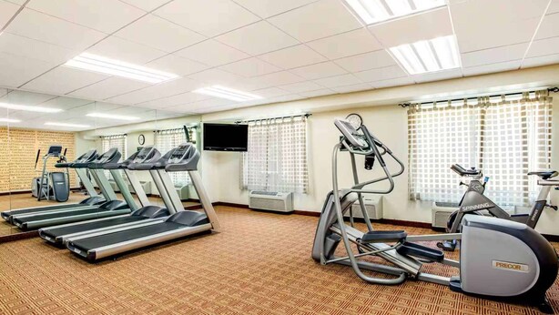 A gym with treadmills, an elliptical, and a stationary bike.