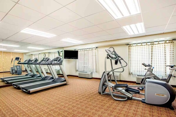 A gym with treadmills, an elliptical, and a stationary bike.