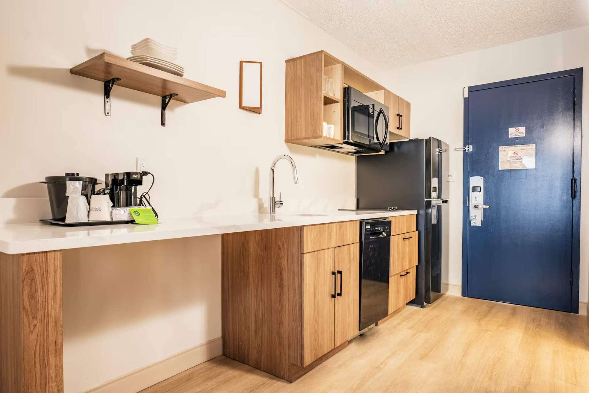 A compact kitchen with a microwave, refrigerator, and dishwasher.