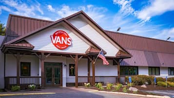 A VANS store with a prominent sign, an American flag, and a clear sky.
