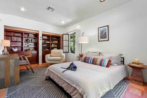 A bedroom with a bed, a chair, a bookshelf, a desk, and a lamp. - Spacious 5-bedroom house in lovely Topanga with cool vibes (Topanga)